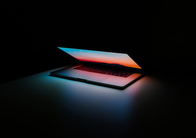 A half opened laptop in the dark